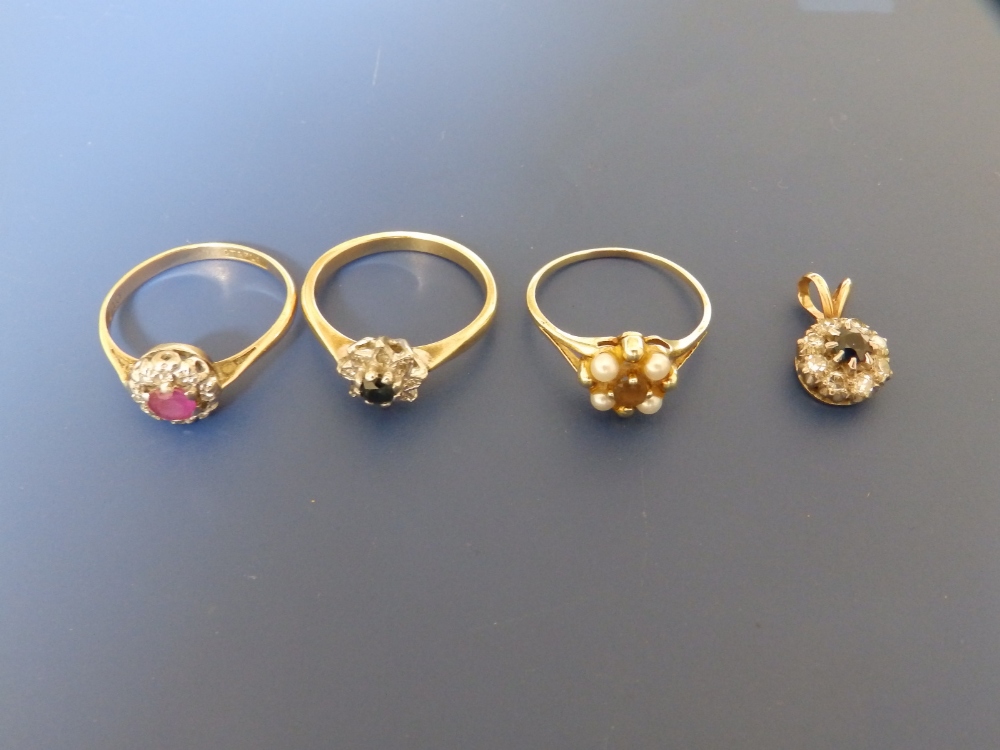 A small ruby & diamond cluster ring, two other cluster rings and a pendant. (4)