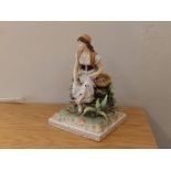 A Volkstedt porcelain figure of a seated woman - a/f.