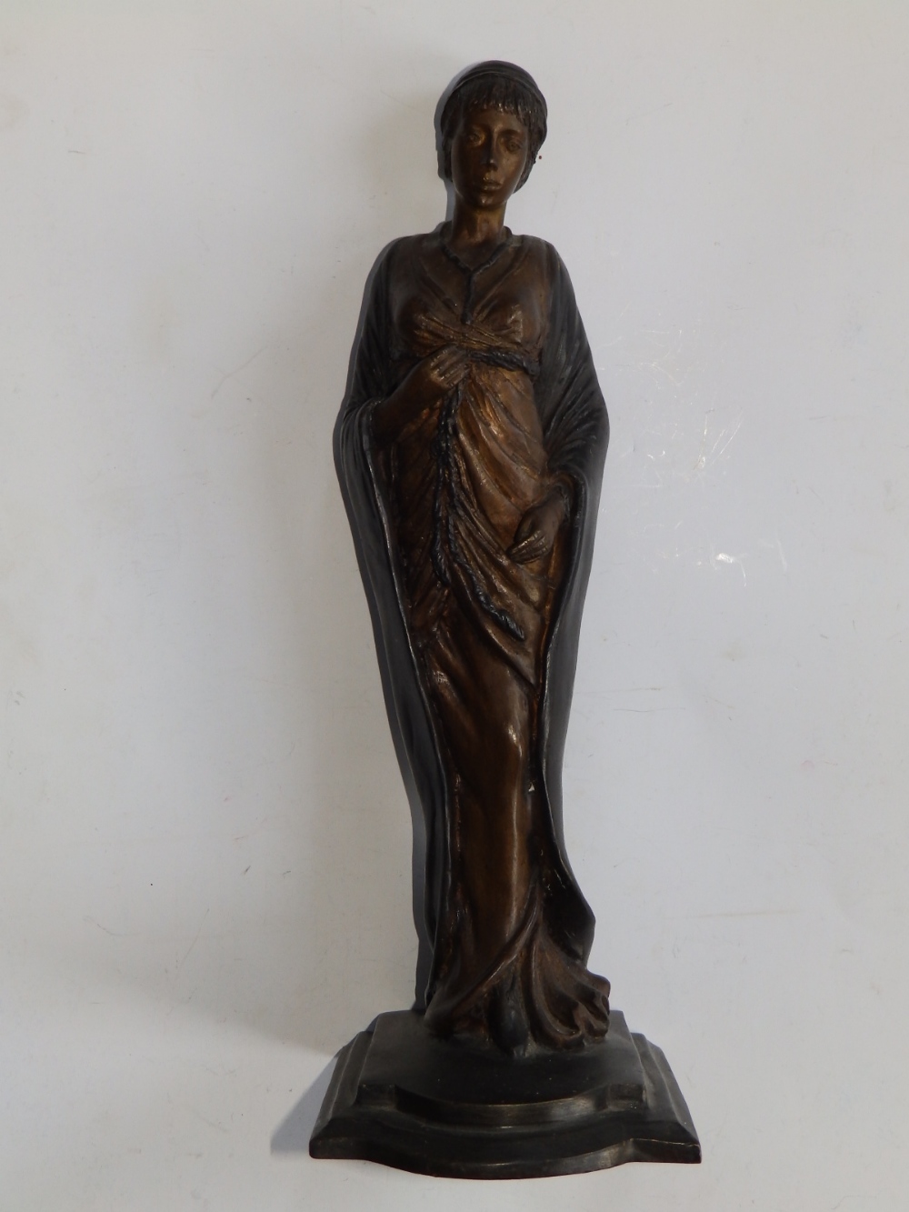 A bronze female figure in long tightly drawn gown, 12" high.