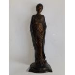 A bronze female figure in long tightly drawn gown, 12" high.