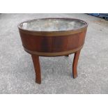 A brass bound oval wine cooler on splayed flattened legs with metal liner, 25.5" across.