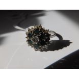 A modern green stone & diamond cluster ring in 18ct white gold. Finger size N/O.