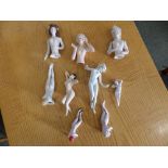 Two old articulated porcelain half-dolls, one other and six nude 'piano dolls'. (9)