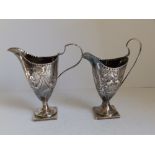 Two 18thC silver helmet shaped cream jugs each on square pedestal foot - Charles Hougham, London.