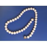 A modern pearl necklace comprising large pearls of uniform size just under 10mm diameter, on 14k