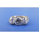 A three stone old cut diamond ring, the central claw set stone weighing approximately 1.45 carats,