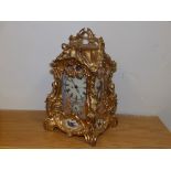 A reproduction gilt metal repeating mantel/carriage clock with painted porcelain panels.