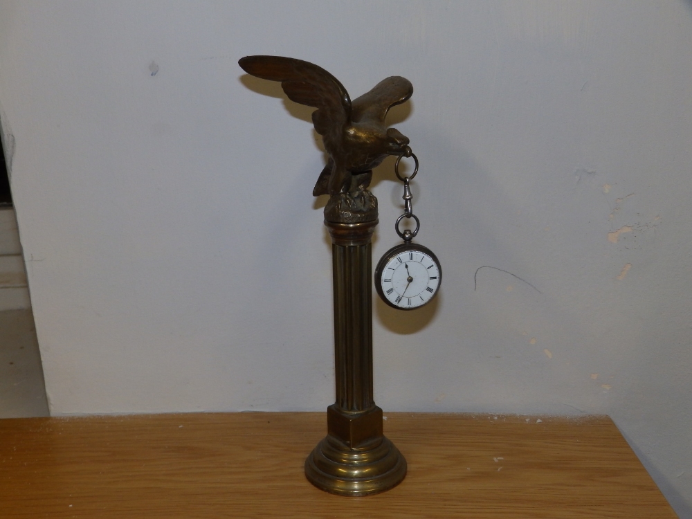 A silver fusee pocket watch on bird of prey stand.