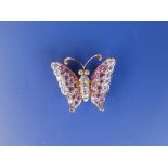 A small modern diamond & pink sapphire set yellow metal butterfly brooch/pendant, 0.75"