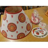 A small Manchester United 1968 European Champions poster, a MUFC lamp shade and rosettes.