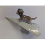 A Lladro puppy on a paper aeroplane.