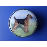 An enamelled silver circular compact, the hinged cover painted with a portrait of a terrier in