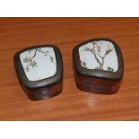 A pair of 20thC lacquered trinket boxes set with panels of antique Oriental porcelain.