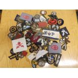 A large quantity of military trade patches and an arm band.