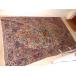 An old millefleur medallion rug featuring pinks and orange with green, purple and blue, 90" x 54"