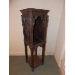 A 19thC Gothic Revival oak two tier stand, the upper tier with arched open front, each corner carved