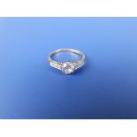 A diamond solitaire, the claw set brilliant weighing approximately 0.50 carat with small diamonds to