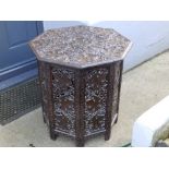 A 19thC Eastern carved octagonal table on folding openwork wooden stand, Width 24"