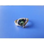 A certified natural green sapphire & diamond ring, the pear shaped stone in cluster setting of