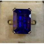 A certified natural tanzanite solitaire ring, the 15.1 carat rectangular cut stone set in four white
