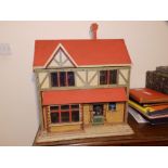 An early 20thC painted wood dolls' house and contents, Height 24", Width 25".