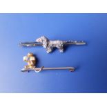 A 15/18ct white metal bar brooch set with a diamond studded spaniel together with a monkey bar