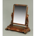 A Victorian mahogany toilet mirror, with scroll supports and serpentine base,