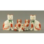 Three orange patch Staffordshire dogs, 19th century, and a pair of Staffordshire orange patch cats,