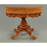 A Victorian walnut turnover top games table, serpentine outline, shaped frieze,