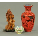 A Chinese carved soapstone figure of a sage, raised on a wooden stand, a cinnabar lacquered vase,