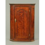 A George III oak hanging corner cupboard,