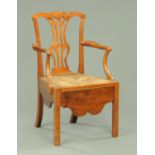 An early 19th century fruitwood armchair, in the Chippendale style, with rush seat and shaped apron.