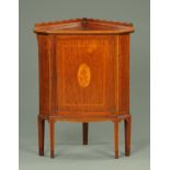 An Edwardian inlaid mahogany low corner cupboard, with shaped pediment,