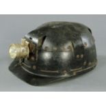 A leather miner's helmet, a plated lamp with label inside for "Huwood Light Type Hat".