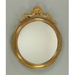 A brass framed convex wall mirror, with shell and scroll pediment, frame diameter 45 cm.