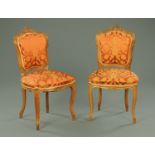 A pair of French side chairs, walnut, with exposed scroll carved showframes, upholstered backs,