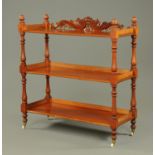 A Victorian mahogany three tier dumbwaiter, with turned columns and raised on ceramic castors.