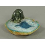 A jade bear with fish, raised on a polished part Geode. Length 10 cm.