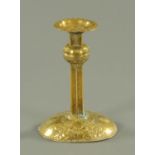 A late 19th century Arts & Crafts embossed brass pricket type candlestick, with weighted base.