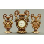 A Continental Majolica clock garniture, the clock with single-train movement. Clock height 34 cm.