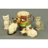 Four Royal Doulton cat ornaments, and a Beswick "Pistol with Wit or Steel" mug. Tallest 10 cm.