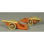 A pair of mahogany and brass chimney ornaments, in the form of cannons. Length 32 cm.