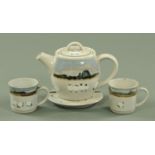 A Highland stoneware hand painted teapot, trivet and two cups,