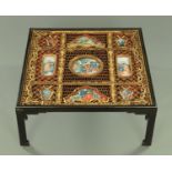 A Chinese low table, with fretwork and reverse painted glass panels,