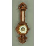 A large Edwardian carved oak banjo barometer, aneroid, with fruit and foliate carved case,