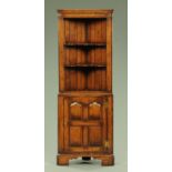 An oak corner cupboard by Titchmarsh & Goodwin, mid 20th century, with applied label "Siesta",