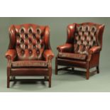 A pair of oxblood leather button back wing armchairs, 20th century,