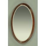 A mahogany framed mirror, oval, with bevelled glass, circa 1930. Width 93 cm.