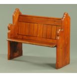 A Victorian pitch pine pew, of small proportions and with silhouette ends, width 106 cm.