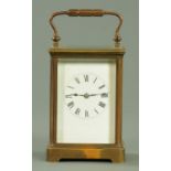 An Edwardian brass cased carriage clock, the enamel dial with Roman numerals, striking on a gong.